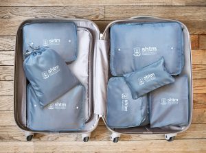 Open suitcase isolated on old wooden background Open travel suitcase isolated on old wooden background
